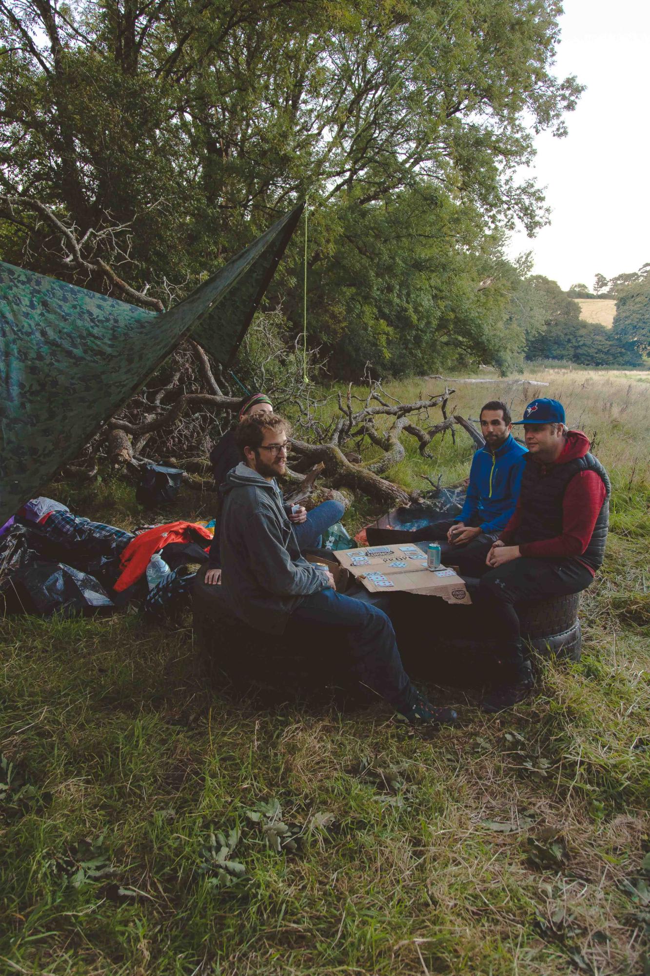 A group of campers enjoy a game of cards at Bush Farm Campsite.