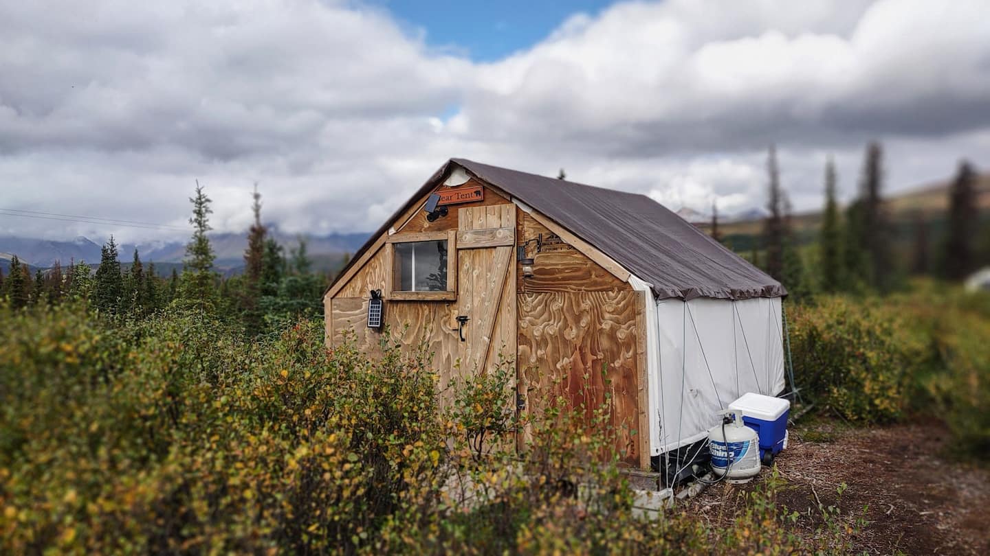 The front view of the tent, with a solid latching door and small window.